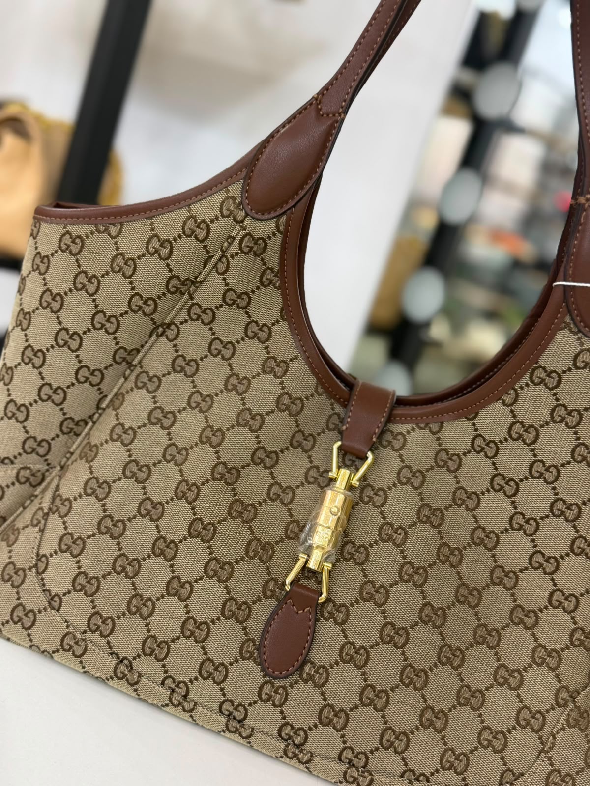Gucci Mercato tote bag features signature GG canvas and a golden piston closure