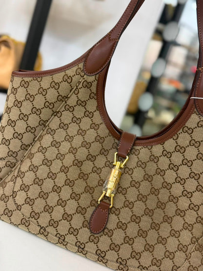 Gucci Mercato tote bag features signature GG canvas and a golden piston closure