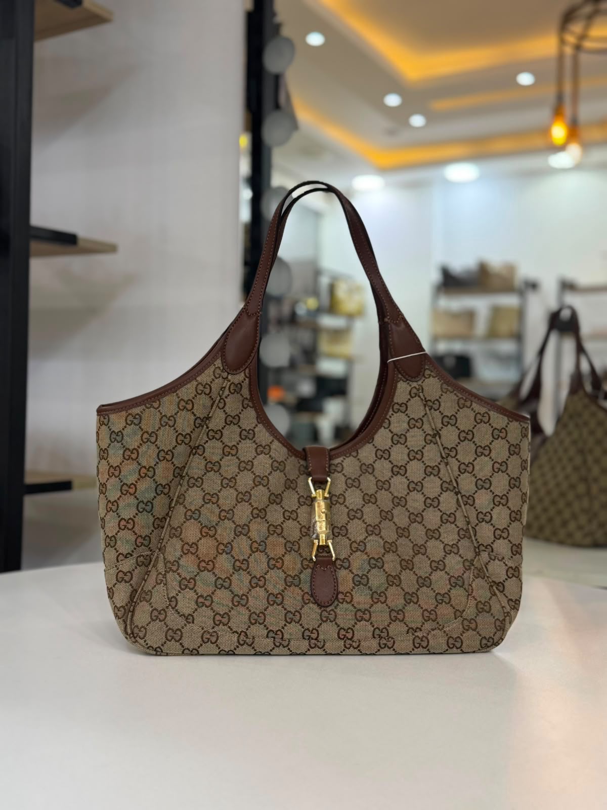Gucci Mercato tote bag features signature GG canvas and a golden piston closure