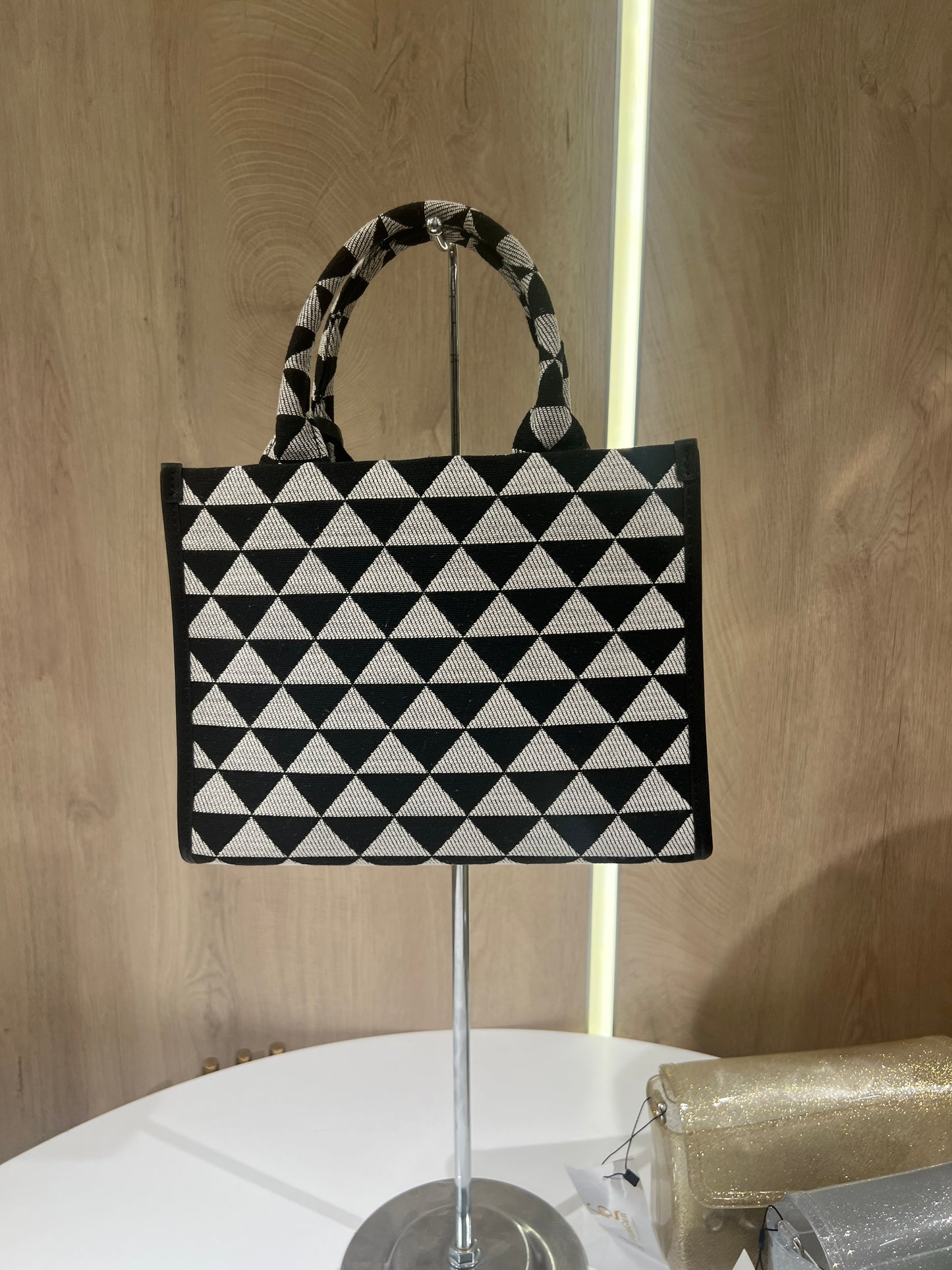 Prada Symbole Jacquard fabric handbag features a black and beige geometric pattern adorned with yellow and green embroidered floral motifs