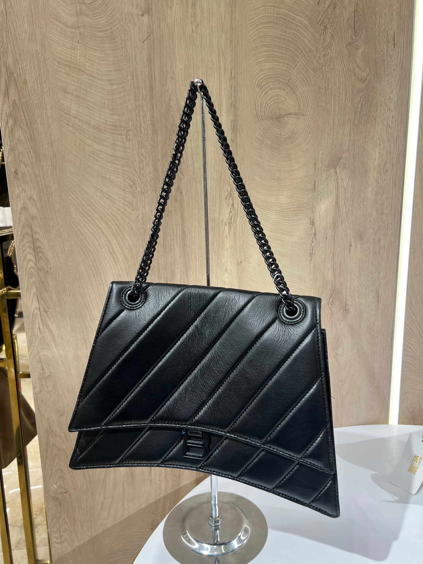 Balenciaga Crush quilted shoulder bag is crafted from black leather and features a signature black-tone B-shaped plaque