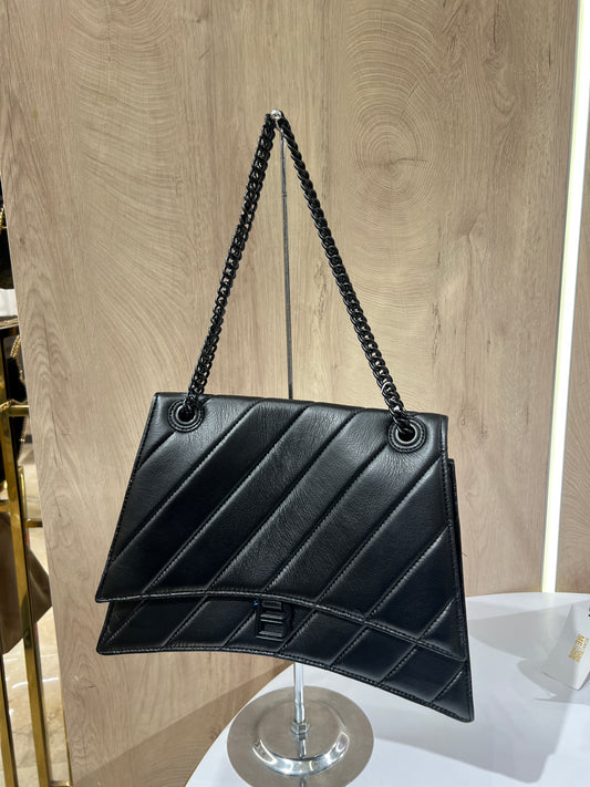 Balenciaga Crush quilted shoulder bag is crafted from black leather and features a signature black-tone B-shaped plaque