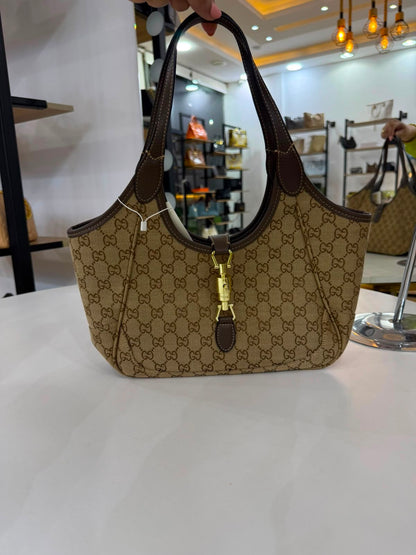 Gucci Mercato medium Tote Bag is crafted from monogrammed GG canvas with dark brown leather trim